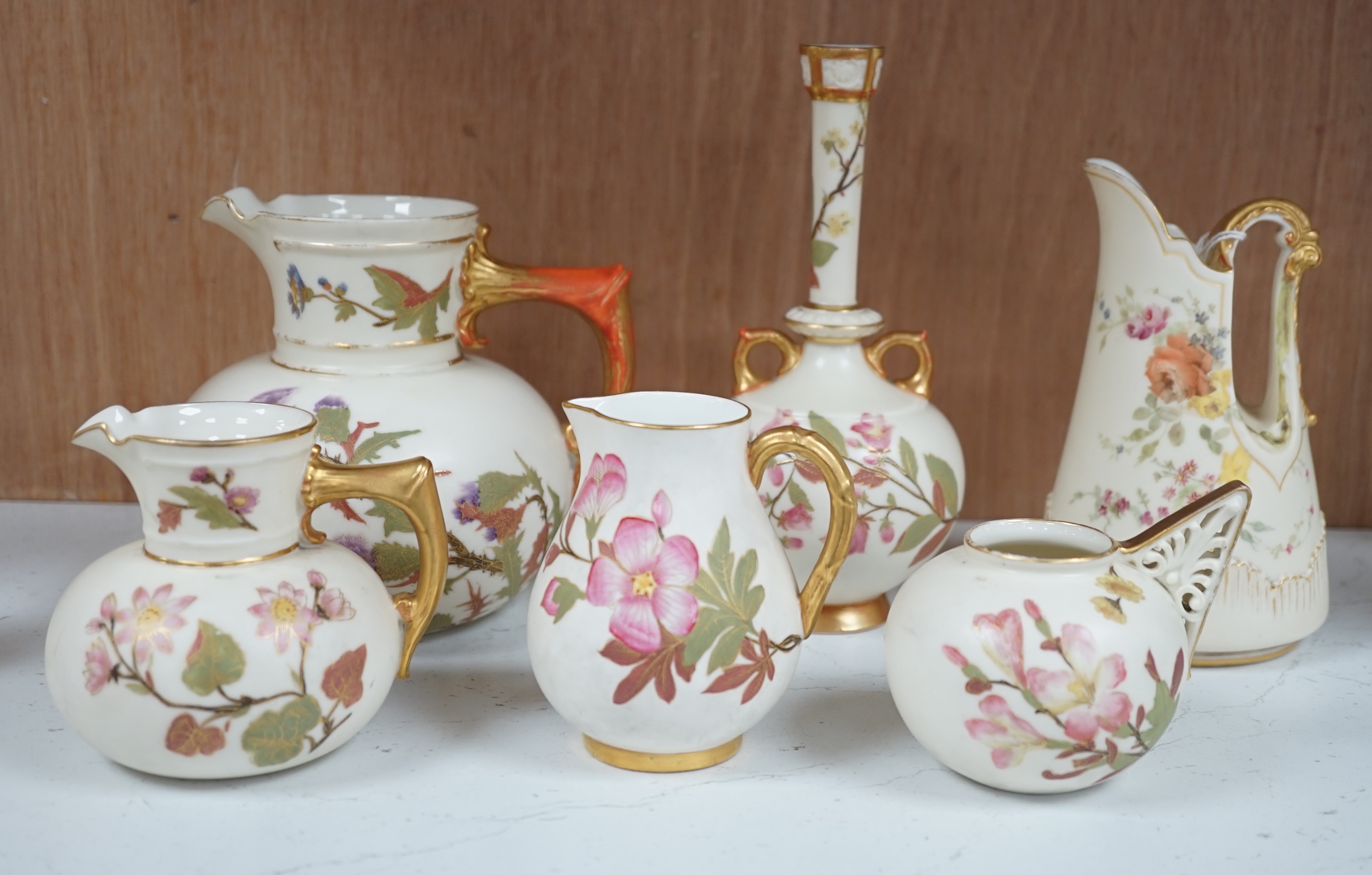 Four Royal Worcester ivory ground and gilt decorated vases and a handled posy pot and tall stemmed vase, 18.5cm high. Condition - some gilt decoration worn